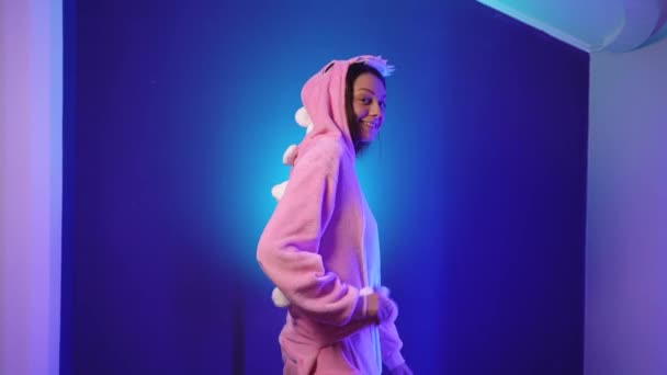 Ung kvinna i rosa pyjamas lekfullt och roligt leker med svansen — Stockvideo
