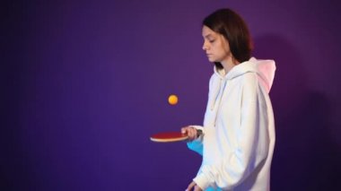 Beyaz kapüşonlu ve elinde tenis raketiyle bir kız.