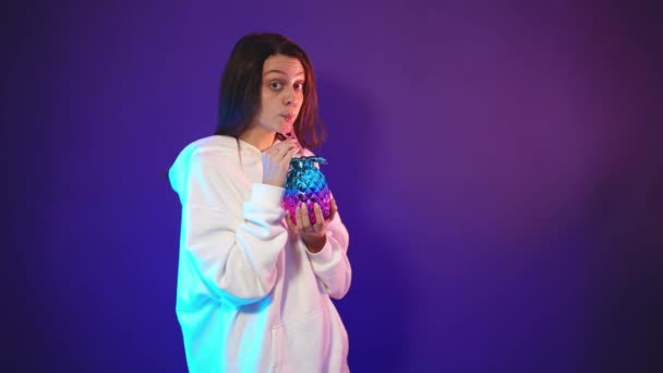 Młoda kobieta trzyma w rękach piękny neonowy kubek koktajlowy — Wideo stockowe