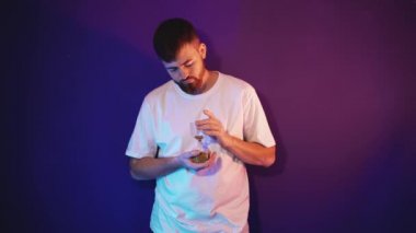 Sakallı genç adam elinde kum saati tutuyor.