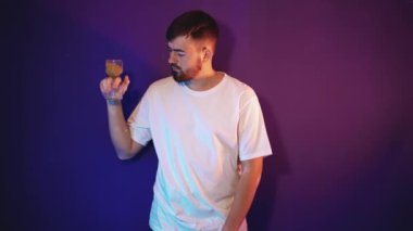Sakallı genç adam elinde kum saati tutuyor.