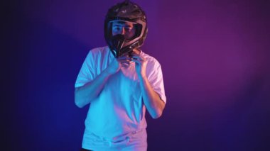 Sakallı adam motosiklet kaskı takıyor.