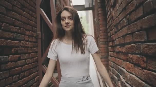 Beautiful woman walking in a vintage tunnel with brick walls — Stock Video