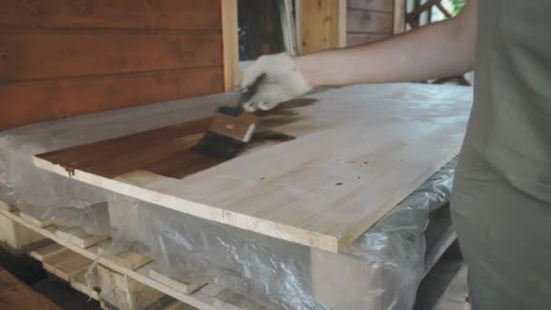 Una mano con guantes mans cubre suavemente la mesa de madera con un cepillo — Vídeos de Stock