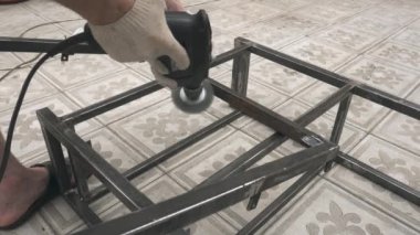 Elinde matkapla bir adamın eli metali iyice temizler.