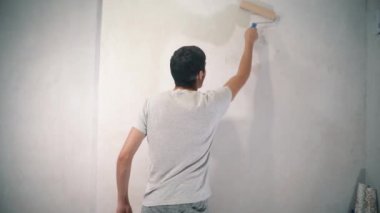 Young man with a roller in his hands