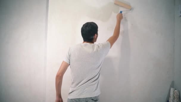 Young man with a roller in his hands — Stock Footage Young man with a roller in his hands Stock Footage