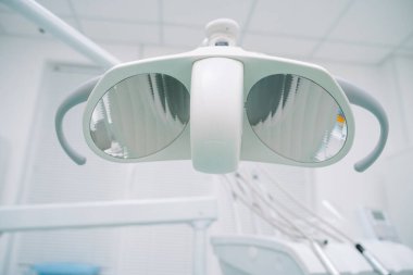 Shadowless cold lamp in dental clinic, doctor and patient office, close-up