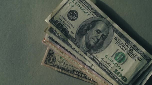 Hand gooit snel dollarbiljetten op tafel, zachte groene achtergrond — Stockvideo
