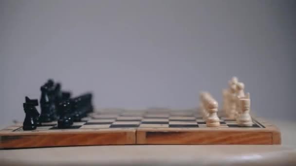 Шахова дошка з відкритими фігурами, обертання дошки руху, сірий фон — стокове відео