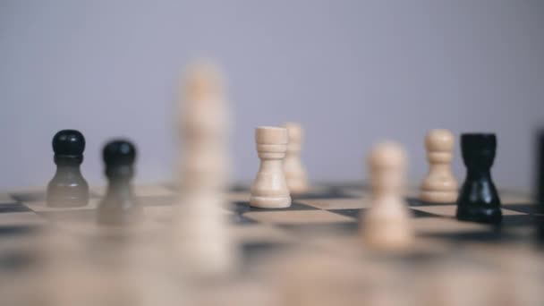 Une fille joue aux échecs, une main de femme porte prudemment une tour noire — Video