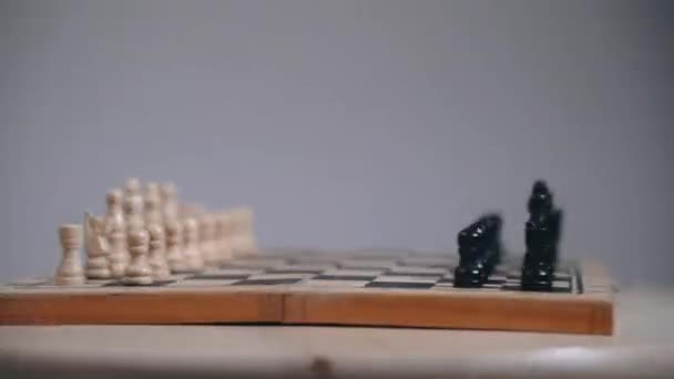 Placa de xadrez com peças expostas, movimento de placa giratória, fundo cinza — Vídeo de Stock