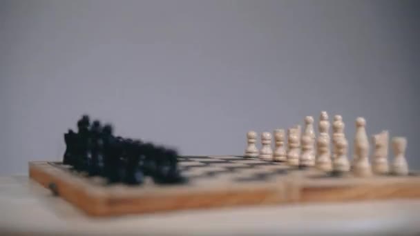 Placa de xadrez com peças expostas, movimento de placa giratória, fundo cinza — Vídeo de Stock