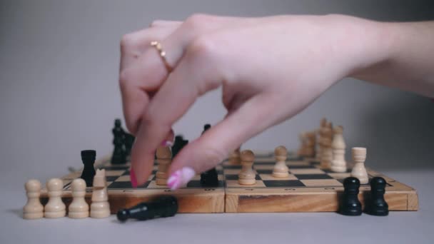 O tabuleiro de xadrez em que o jogo ocorre, a mão das mulheres faz um movimento — Vídeo de Stock