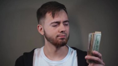 Bir dolarlık banknot ve Rus rublesi tutan genç adam, rubleyi atıyor.