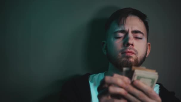 A fiatalember lenyűgöző mennyiségű dollárt tart a kezében. — Stock videók