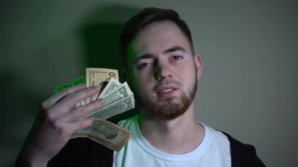 Young man holding dollar bills in his hands, throwing them up — Stock Video