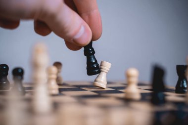 İş adamı satranç tahtası konseptinde satranç taşı taşıyor 