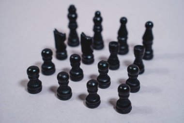 Siyah satranç taşları gri izole arkaplanda kare şeklinde duruyor