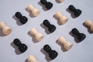 Siyah ve beyaz satranç taşları gri izole arkaplanda düzenlenmiştir.