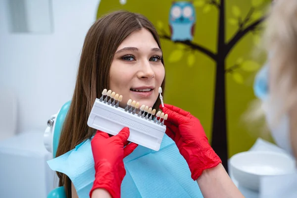 Dentista seleciona a cor dos folheados para o cliente — Fotografia de Stock