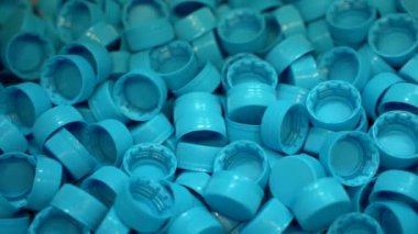 Saf kaynak suyu şişeleme tesisinde çok sayıda plastik şişe kapağı