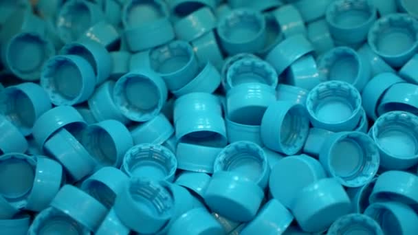 Un gran número de tapas de botellas de plástico en una planta embotelladora de agua de manantial pura — Vídeos de Stock