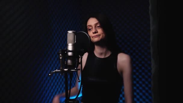 Jovem mulher enérgica em estúdio de gravação cantando uma música e dançando — Vídeo de Stock