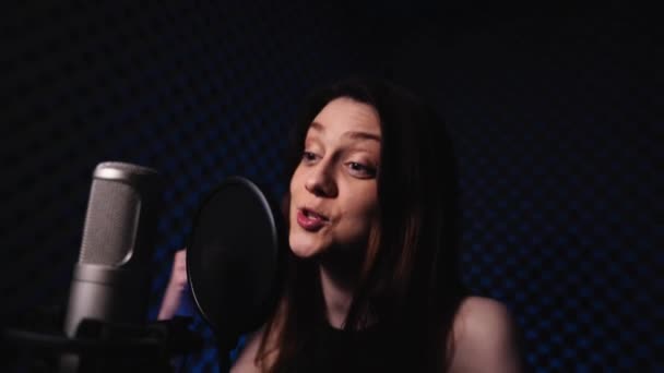 Молода жінка записує ліричний реп в студії звукозапису — стокове відео