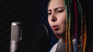 Kayıt stüdyosunda siyah saçlı genç bir kadın.