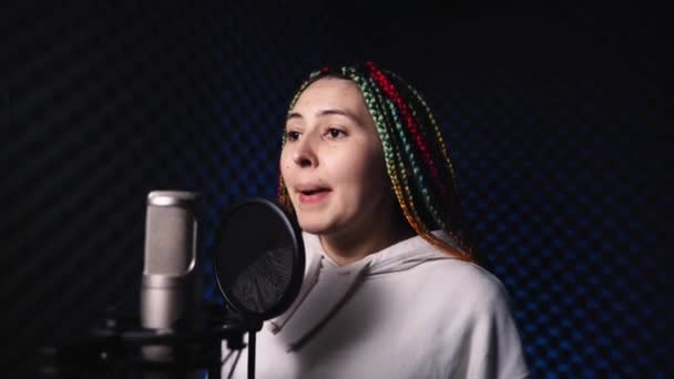 Молодая женщина с цветными волосами стоит в студии звукозаписи — стоковое видео