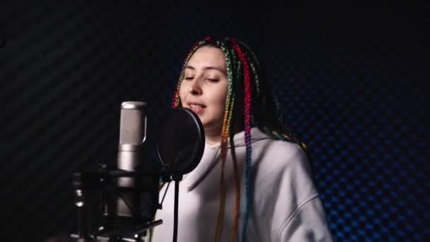 Bright emotional woman with colored hair is recording a song — Stock Video