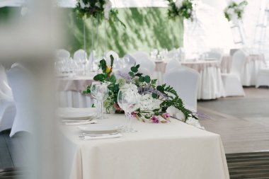 Doğal ve yapay çiçeklerle dekoratif masa dekorasyonu, el yapımı kompozisyonlar, beyaz düğün çadırı.