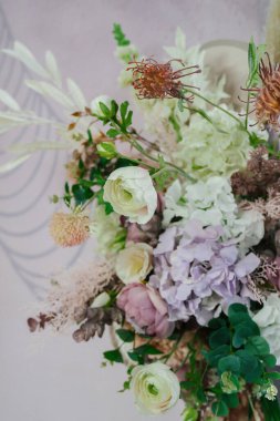 Düğün hacimli fotoğraf alanını yapay ve doğal çiçeklerle süslemek, hassas bitkilerin bir bileşimi.