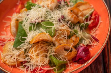 Rendelenmiş peynirli ve kiraz domatesli Sezar salatası menü için fotoğraf, ahşap arka plan.