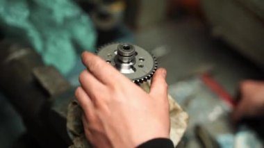 Bir adam çekiçle motor kapakçığından bir yıldızı düşürüyor.