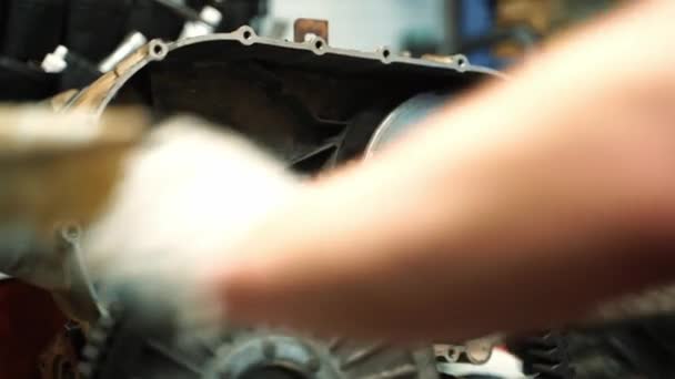 Un uomo in guanti da lavoro assembla una scatola CVT per un ATV, lavori di riparazione — Video Stock