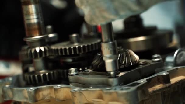 Een man trekt de bouten in de ATV-motor vast met een schroevendraaier en een moersleutel — Stockvideo