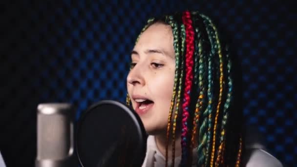 Renkli saçlı ve şarkı söyleyen bir kızın yüzüne yakın çekim — Stok video