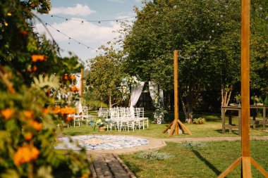 Yeşil sokaktaki çıkış kaydında düğün kemeri, çiçek süslemesi, turuncu rowan.