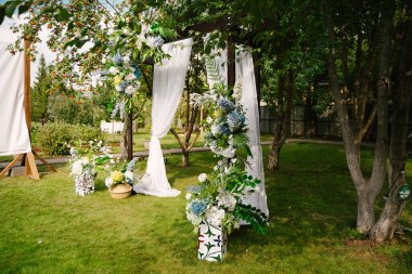 Yeşil sokaktaki çıkış kaydında düğün kemeri, çiçek süslemesi, turuncu rowan.