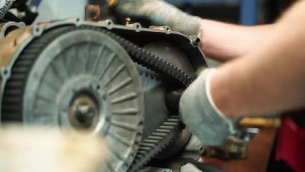 Ένας άνδρας με γάντια εργασίας συναρμολογεί ένα κουτί CVT για ένα ATV, εργασίες επισκευής — Αρχείο Βίντεο