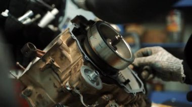 Erkek çilingir bir ATV motoruna conta takıyor.