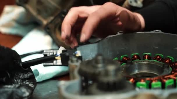 Een man slotenmaker zet kit op een ATV motor — Stockvideo