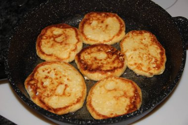  Kızartma tavasında kızartılmış 6 süzme peynirli kek.