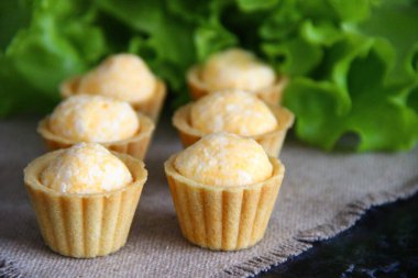 Arka planda taze otlar ve peçeteyle doldurulmuş küçük turtalar.