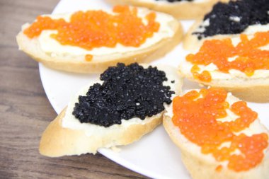 Tereyağlı ve havyarlı sandviçler (kırmızı ve siyah) beyaz tabakta