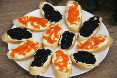 Tereyağlı ve havyarlı sandviçler (kırmızı ve siyah) beyaz tabakta