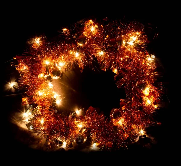 Yeni yılı kutluyoruz ışık çelengi, Noel ağacı süslemesi ve sarı parlak süslemeli çelenk oval çerçeve siyah arka planda izole edilmiş boş metin için boş kopya alanı — Stok fotoğraf