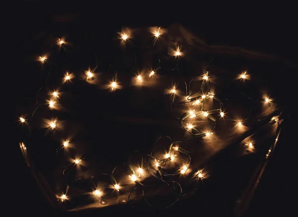 Hjärtformade nyår jul semester firande ljus krans på svart bakgrund. En ram med fritt ledigt kopieringsutrymme för text. Bra för romantiska Alla hjärtans dag kort, inbjudningar eller affischer — Stockfoto
